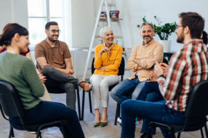 group sitting in a therapy session as part of a rehab aftercare program