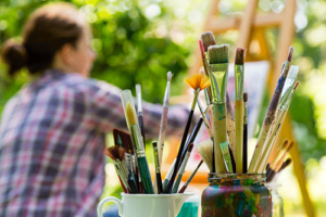 Person painting outdoors as part of art therapy in addiction recovery