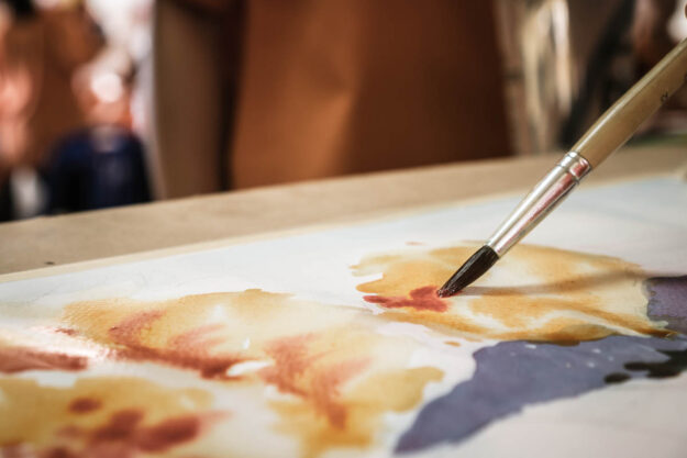 Person painting while enjoying the benefits of art therapy in recovery