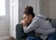 person with head on arm of couch struggling with painkiller dependence symptoms