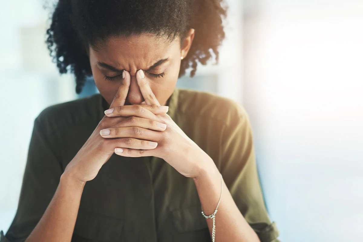 Woman struggling with a headache while experiencing cocaine addiction symptoms