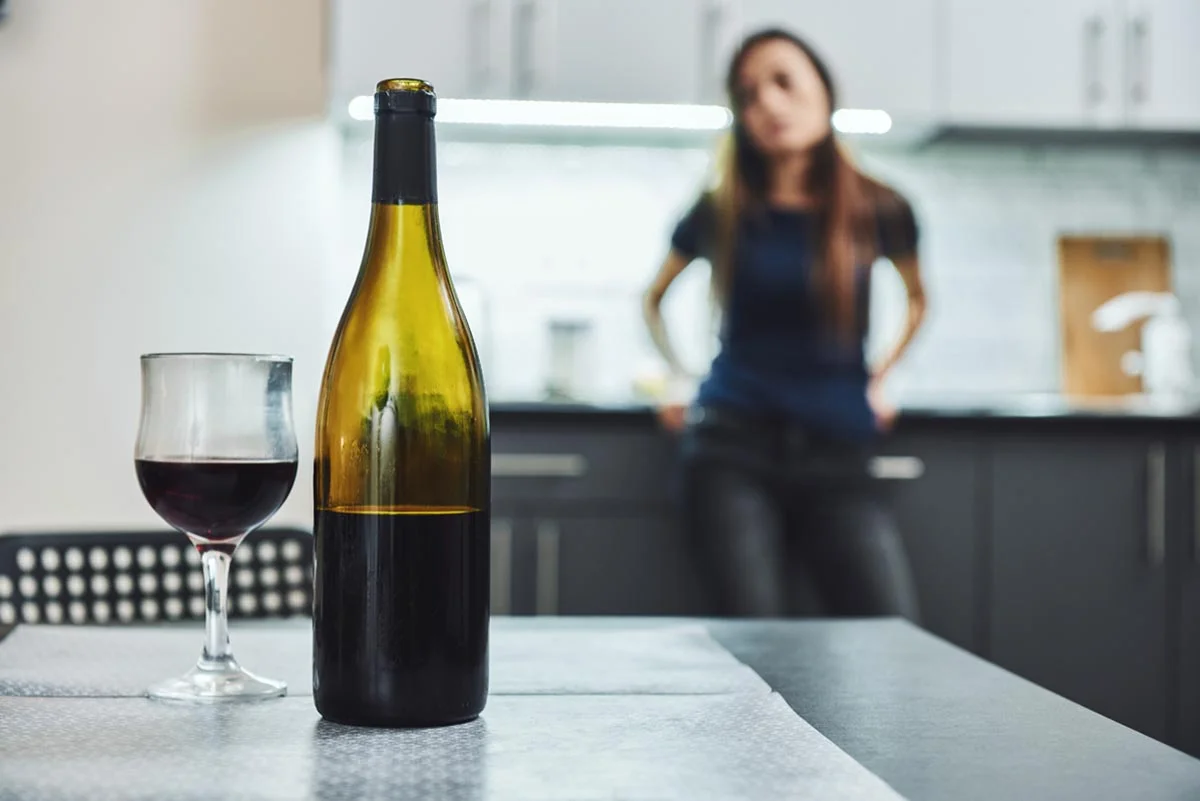 woman looking at wine bottle