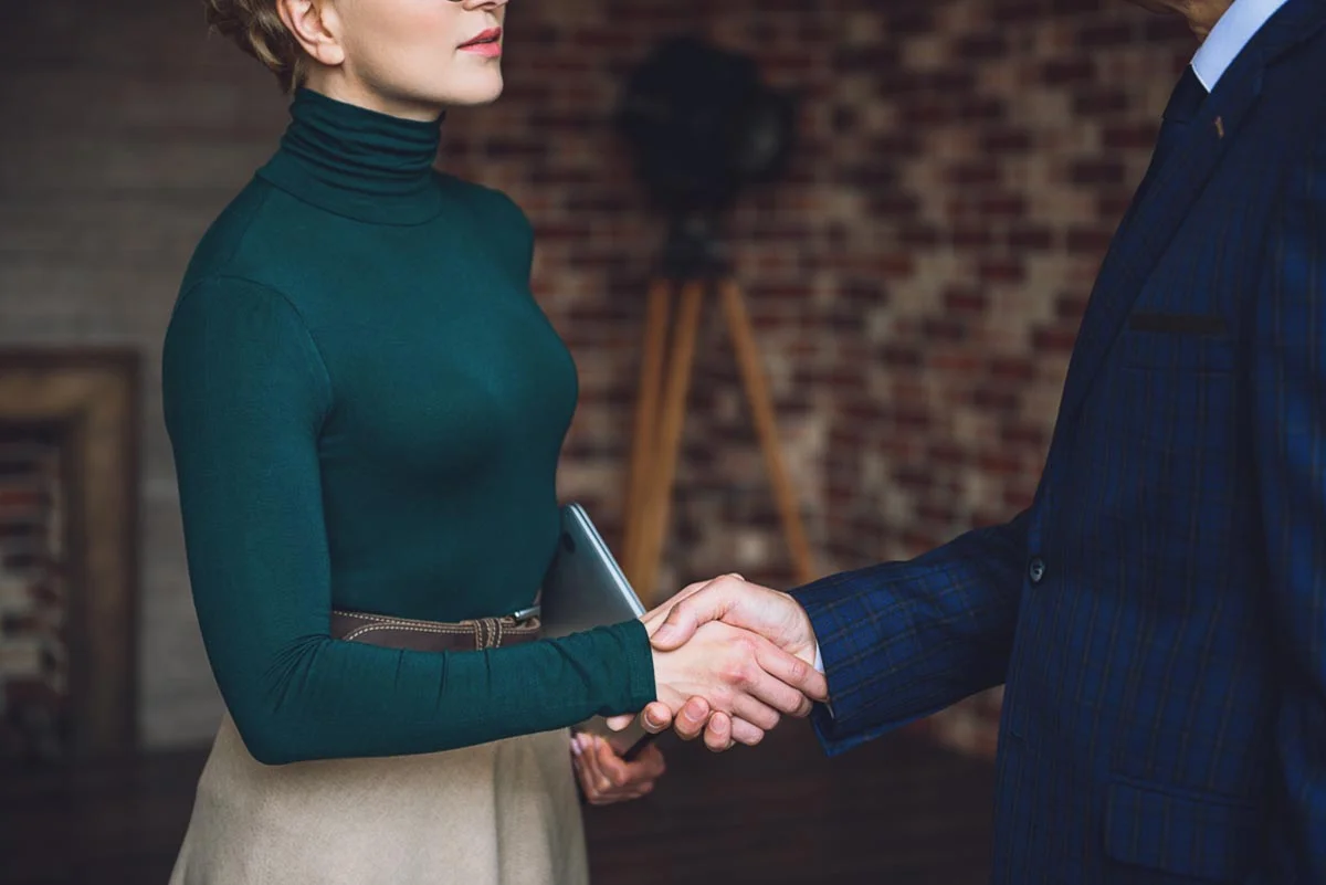woman shaking hands with male