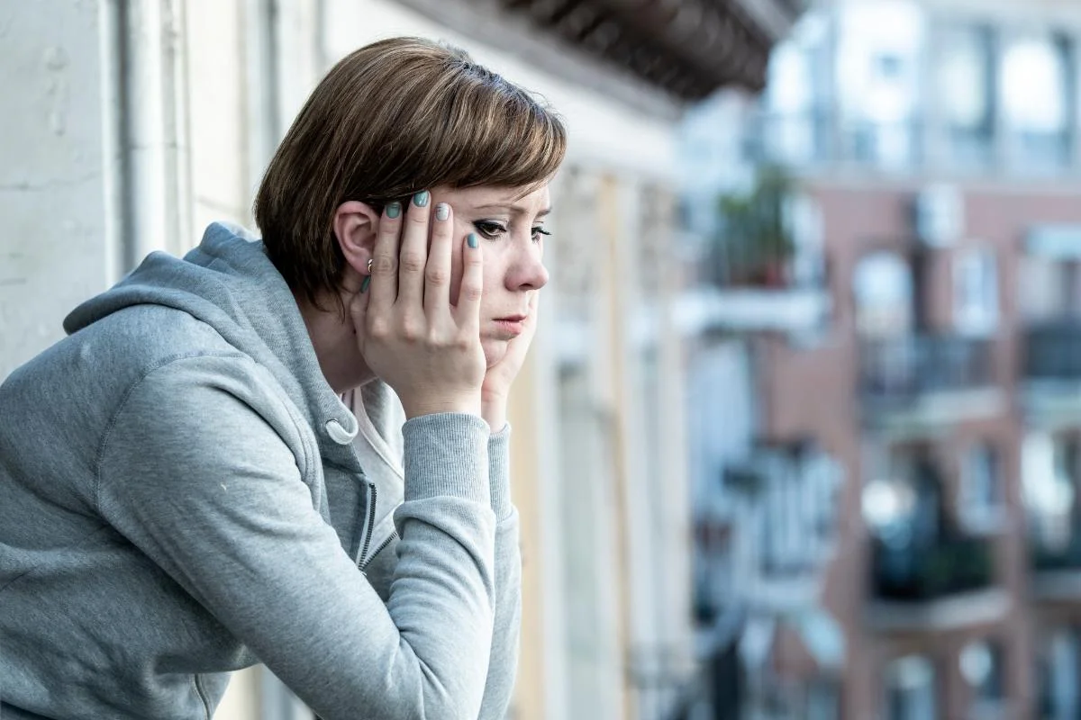 Depressed woman sitting with her hand on her face struggling with benzo addiction symptoms