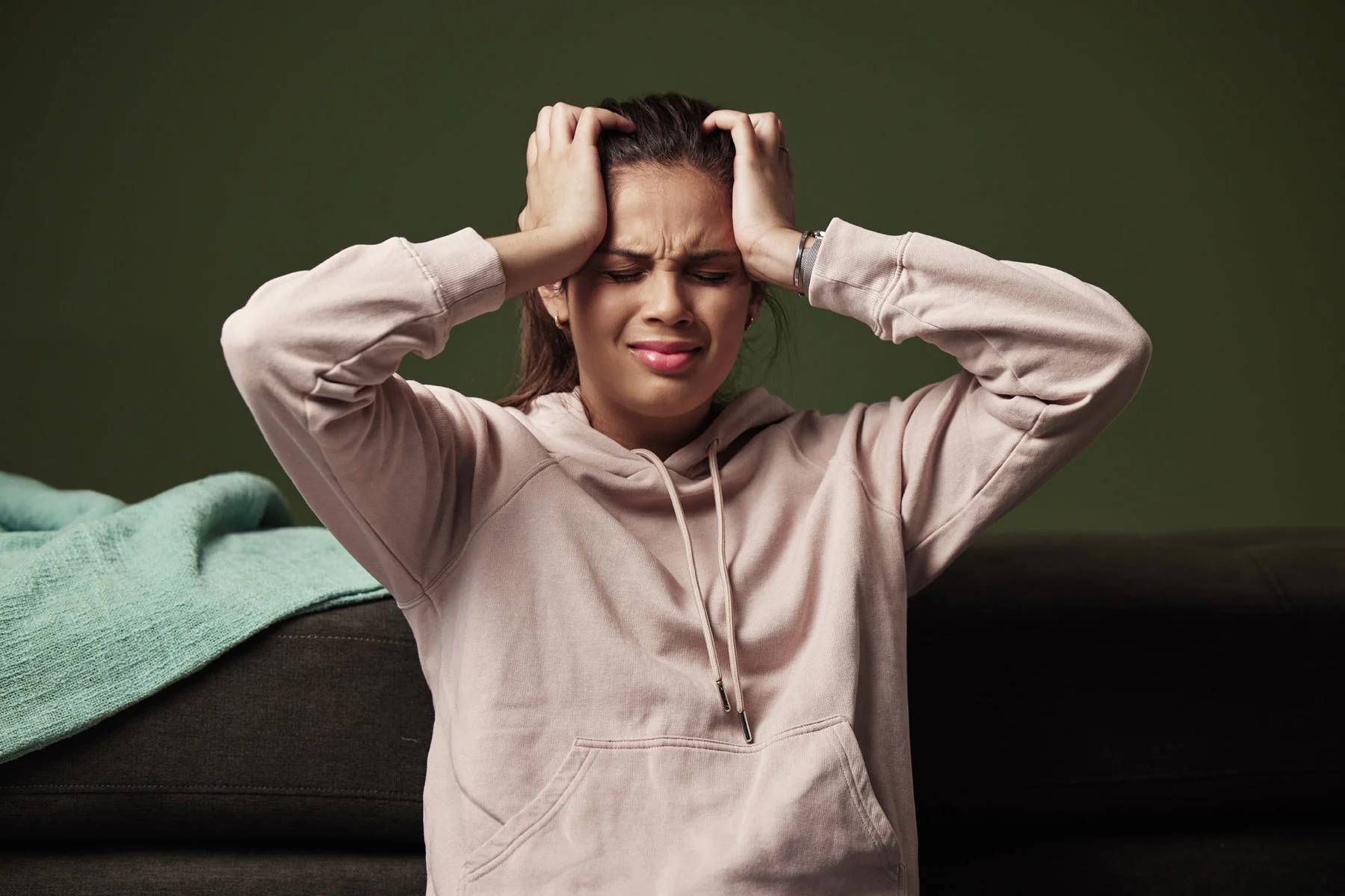 person with hands on forehead struggling with coke overdose symptoms