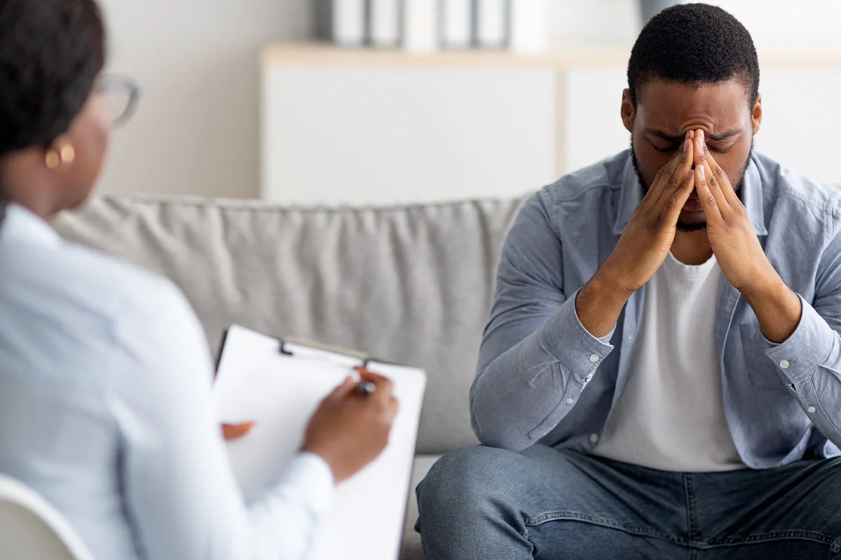 Distressed person in counseling session seeking help for trauma