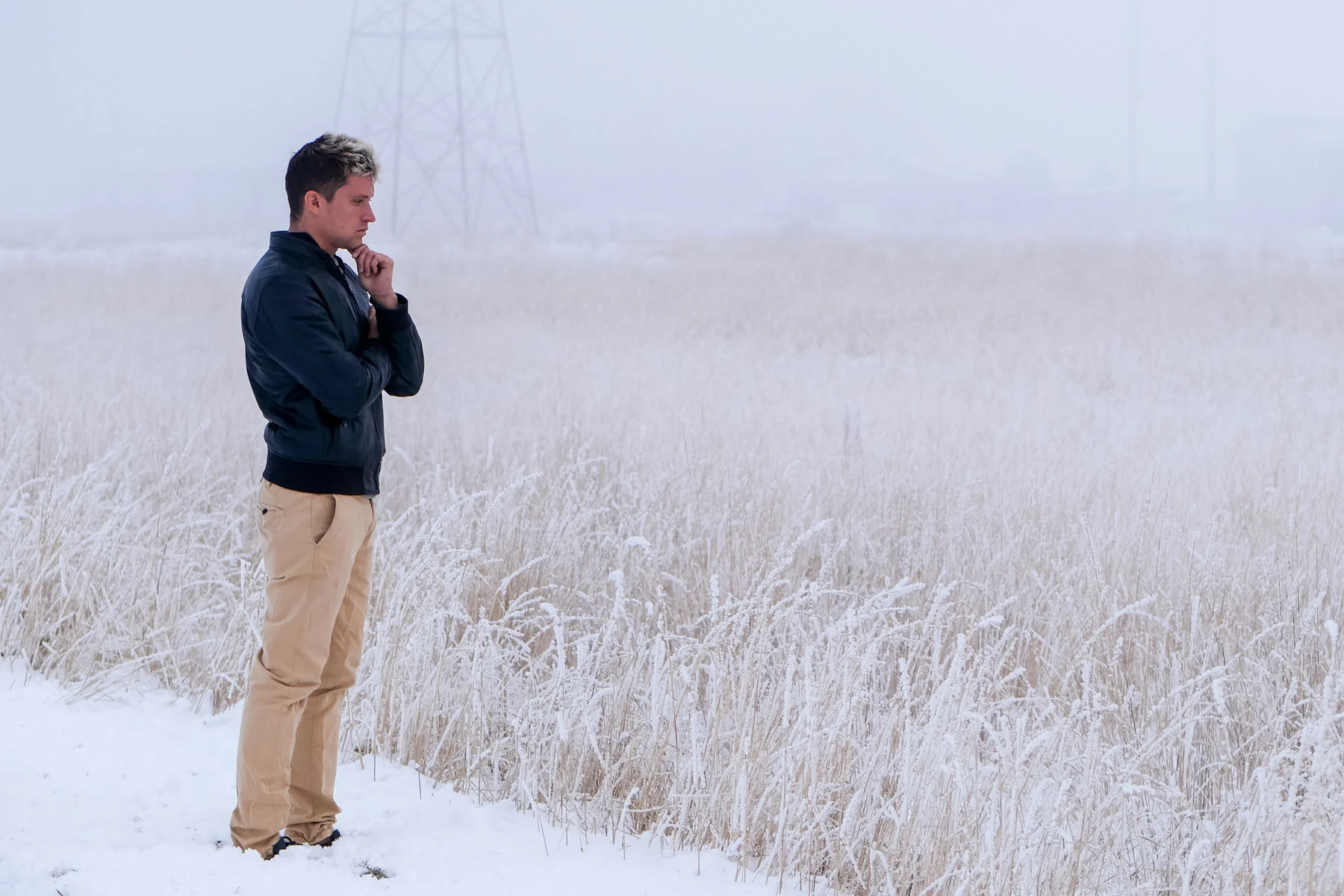 person gazing pensively across a snowy field while experiencing winter depression