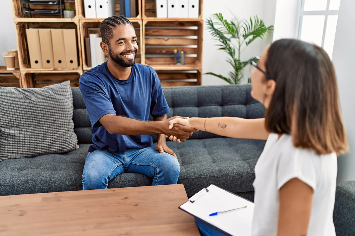 person shaking hands with clinician after learning about levels of care in addiction treatment